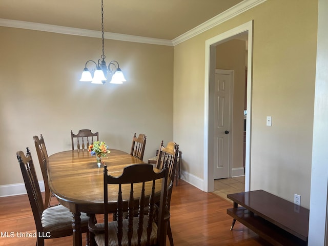 dining room featuring hardwood / wood-style flooring, ornamental molding, and an inviting chandelier