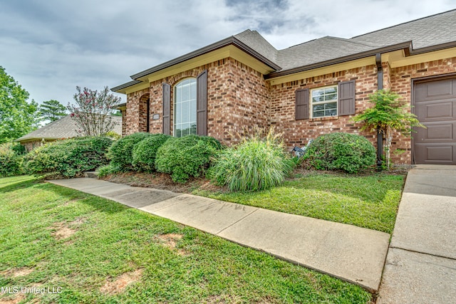 view of home's exterior featuring a garage and a lawn