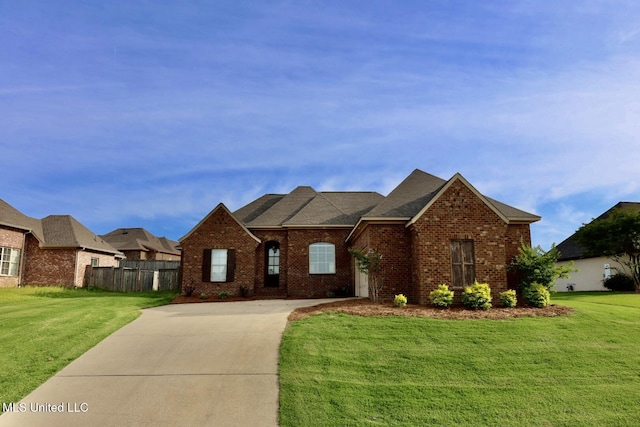 view of front of home featuring a front yard, brick siding, and fence