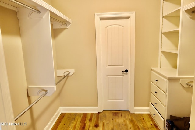 walk in closet with wood finished floors