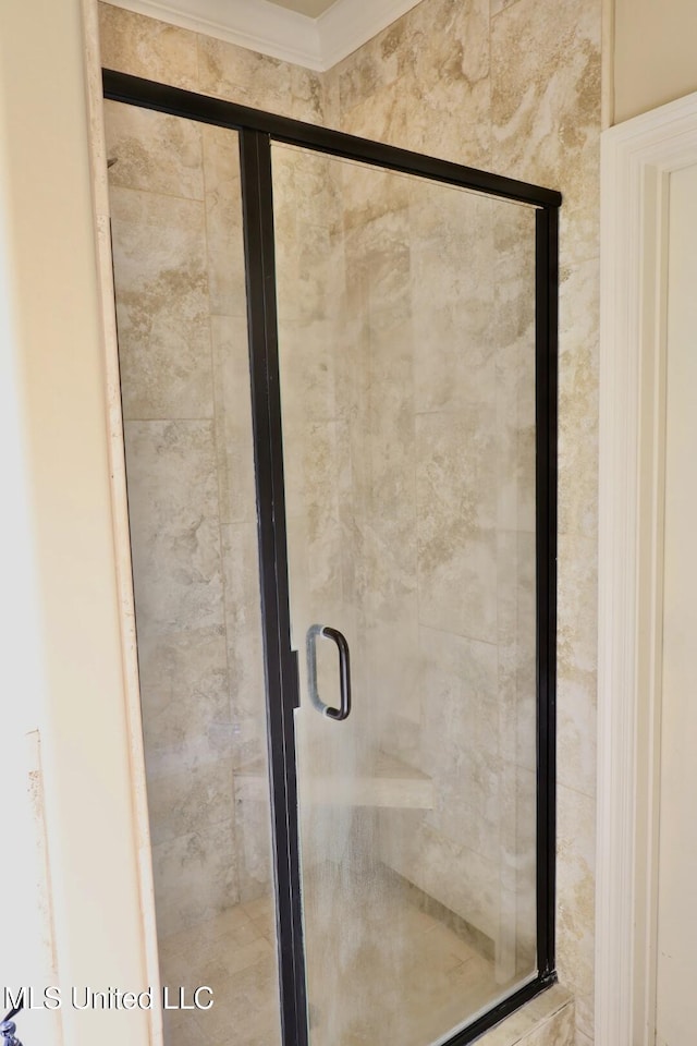 bathroom with a stall shower and ornamental molding