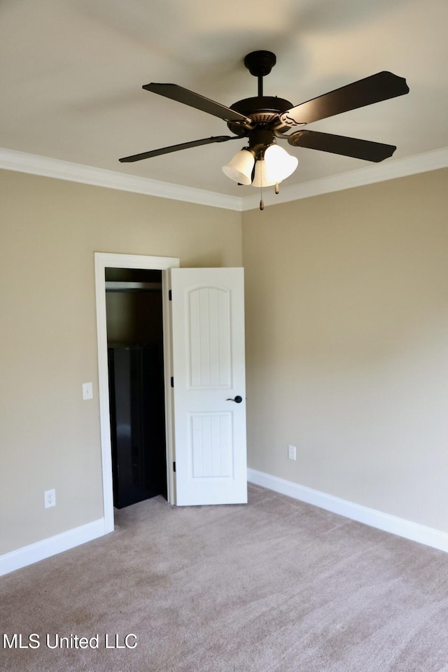 unfurnished bedroom with light colored carpet, crown molding, and baseboards