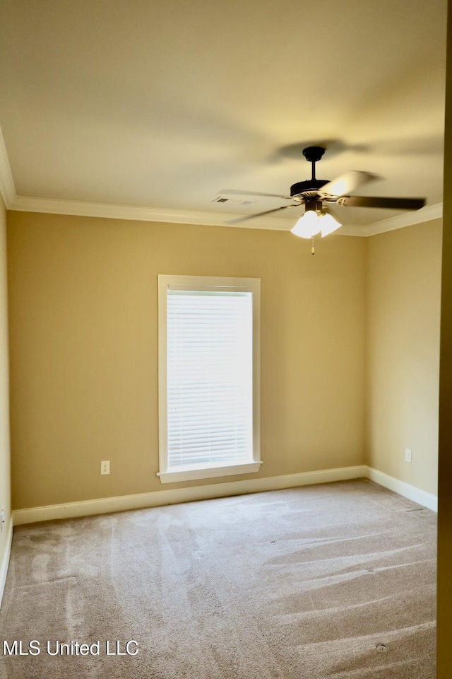 carpeted spare room with ceiling fan, baseboards, and ornamental molding