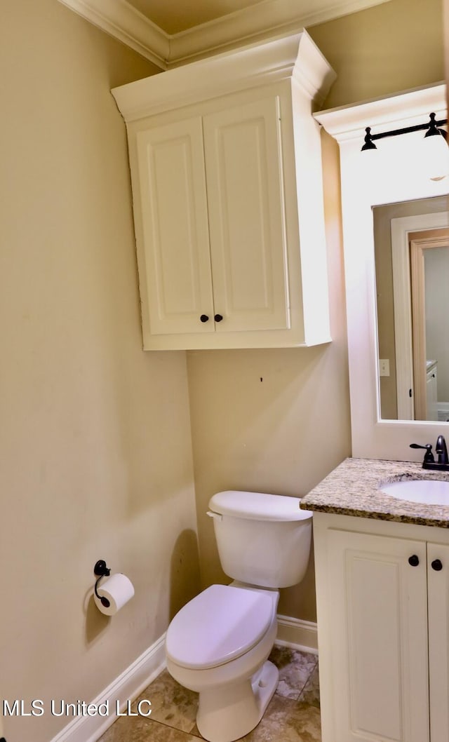 half bath with vanity, toilet, crown molding, and baseboards