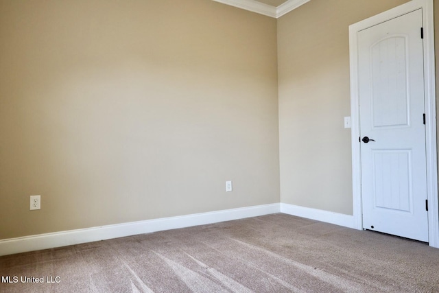 carpeted spare room with baseboards and crown molding