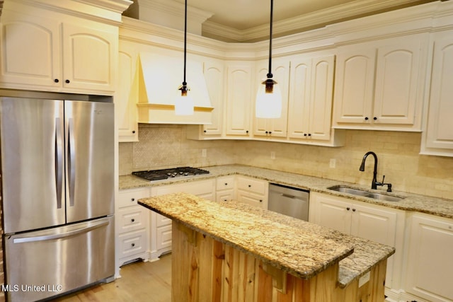 kitchen featuring a sink, decorative backsplash, a center island, light stone countertops, and appliances with stainless steel finishes