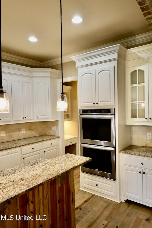 kitchen featuring white cabinetry, stainless steel double oven, and pendant lighting