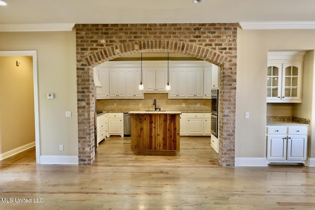 kitchen featuring baseboards, ornamental molding, and a center island