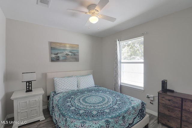 bedroom with a ceiling fan, dark wood finished floors, visible vents, and baseboards