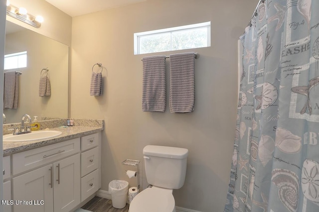 bathroom with toilet, vanity, and a shower with curtain