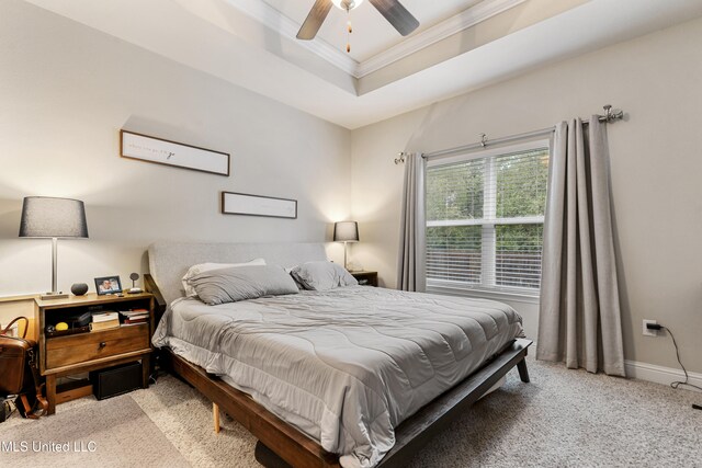 carpeted bedroom with a raised ceiling, ceiling fan, and crown molding