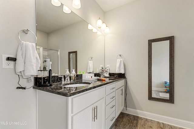 bathroom featuring vanity, wood-type flooring, and a shower with door