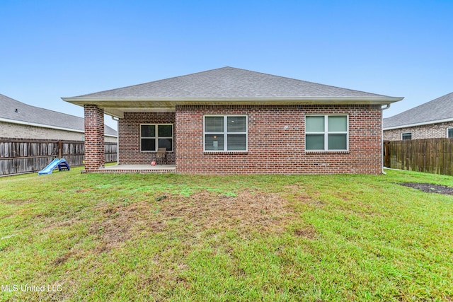 rear view of house with a patio and a yard