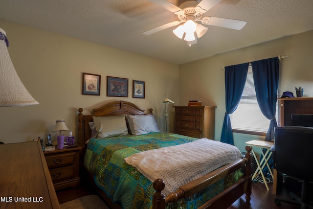 bedroom with dark hardwood / wood-style flooring, ceiling fan, and a textured ceiling