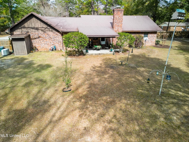 back of property with a shed, cooling unit, a yard, and a patio