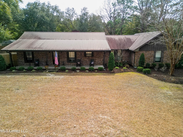 ranch-style house with a front yard and covered porch