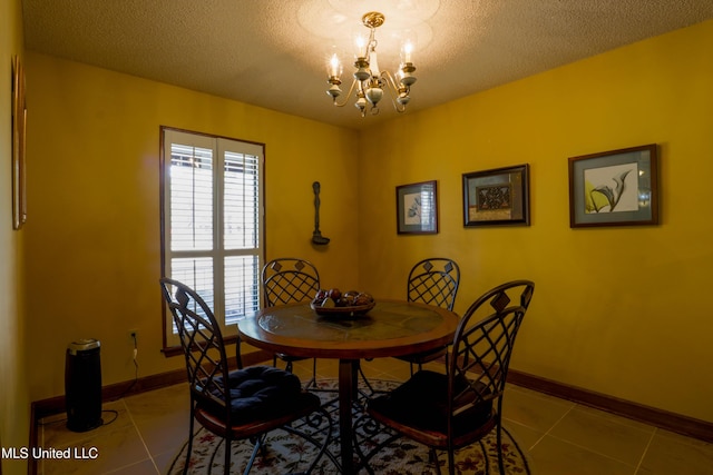 dining space featuring light tile patterned flooring, a chandelier, and a textured ceiling