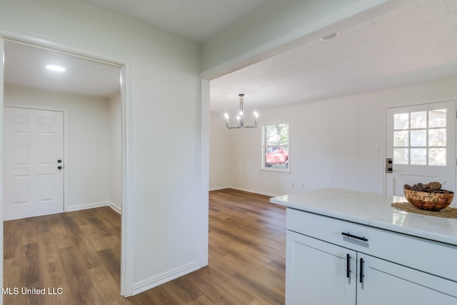 3217 Detroit Ave, Pascagoula, MS 39581 - kitchen featuring wood finished floors, a chandelier, baseboards, and light stone counters