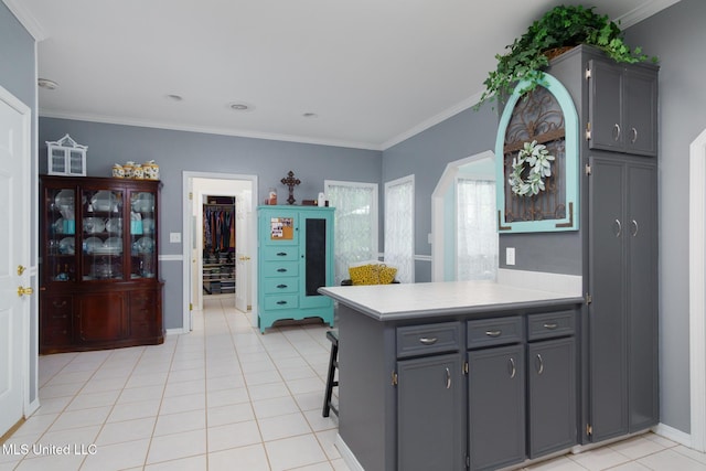 kitchen with a peninsula, light countertops, baseboards, and crown molding