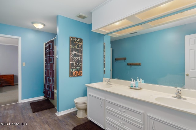 bathroom with wood finished floors, visible vents, toilet, and a sink