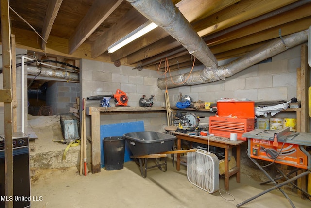 unfinished below grade area with a workshop area and concrete block wall