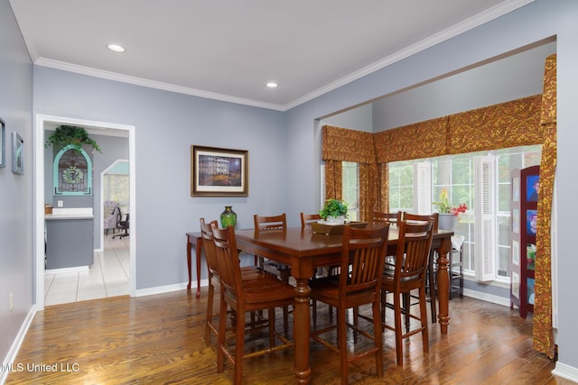 dining area featuring baseboards, ornamental molding, light wood finished floors, and recessed lighting