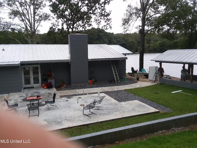 683B Cedar Hill Rd, Flora, MS 39071 - back of property with a chimney, a patio, metal roof, french doors, and a lawn