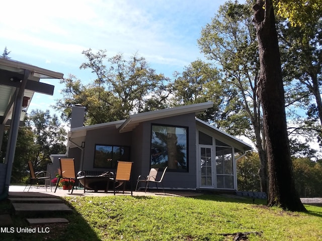 683B Cedar Hill Rd, Flora, MS 39071 - rear view of house with a sunroom, a lawn, a chimney, and a patio area