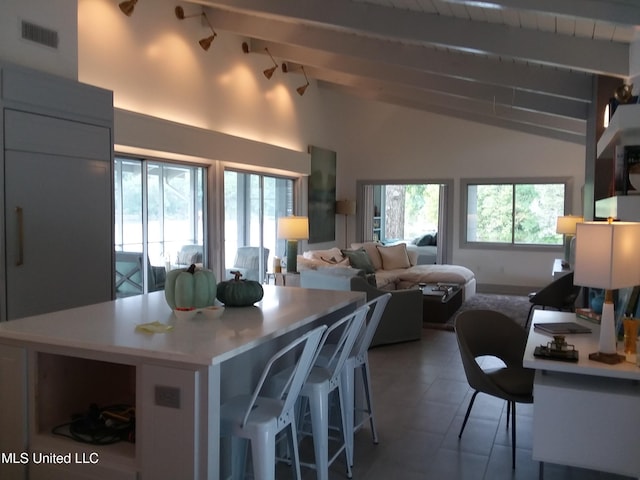 683B Cedar Hill Rd, Flora, MS 39071 - kitchen featuring beam ceiling, light countertops, a kitchen island, a breakfast bar, and tile patterned floors