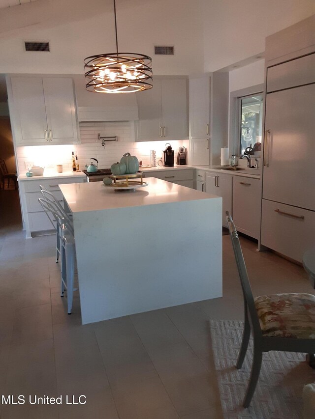 683B Cedar Hill Rd, Flora, MS 39071 - kitchen with backsplash, light countertops, a sink, white cabinets, and a center island