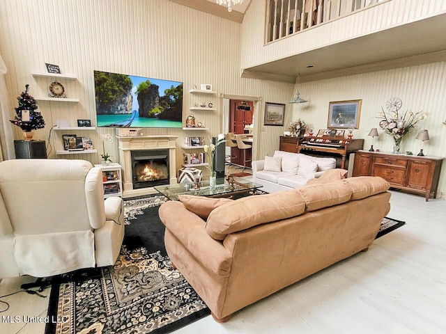 living room featuring a high ceiling, light hardwood / wood-style flooring, and built in shelves