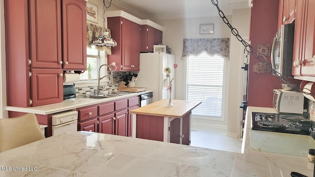 kitchen featuring stainless steel appliances, tasteful backsplash, ornamental molding, and sink