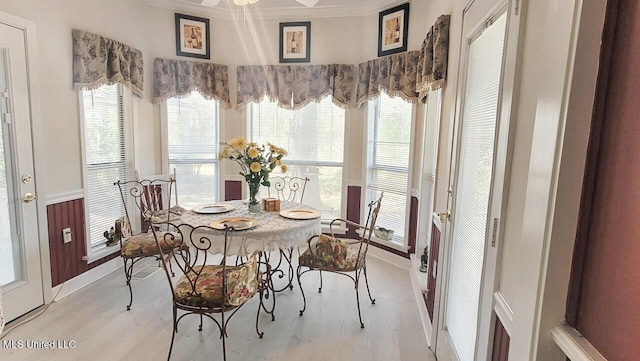 dining area featuring light wood-type flooring and ornamental molding