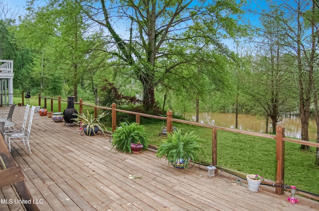 wooden terrace featuring a yard and a water view