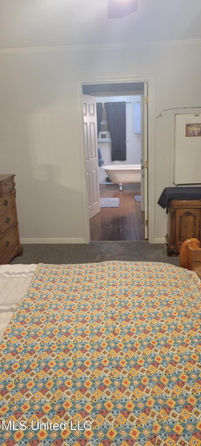 bedroom featuring crown molding and dark wood-type flooring