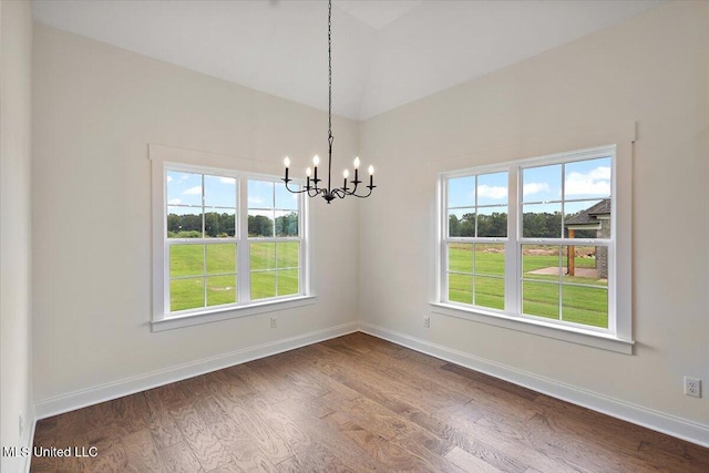 unfurnished dining area with a chandelier, plenty of natural light, and dark hardwood / wood-style floors