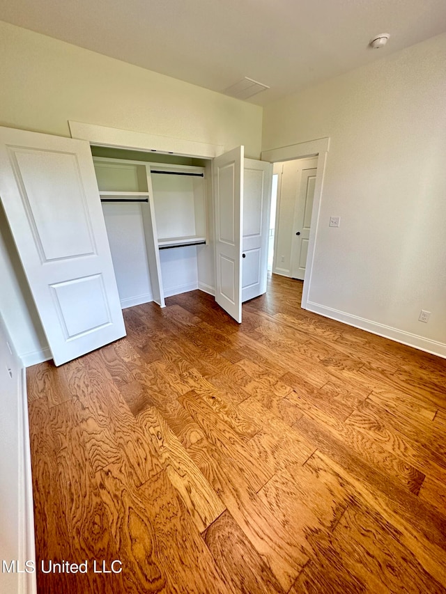 unfurnished bedroom with light hardwood / wood-style floors and a closet