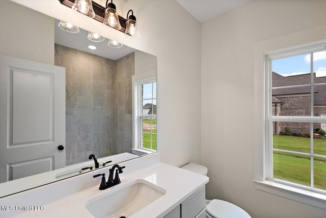 bathroom with a wealth of natural light, vanity, and toilet