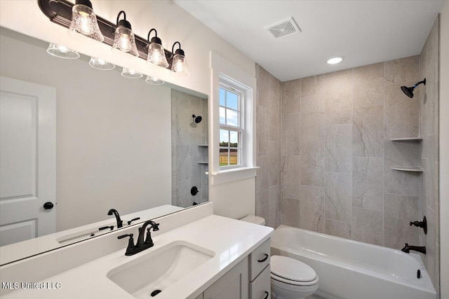 full bathroom featuring vanity, tiled shower / bath combo, and toilet