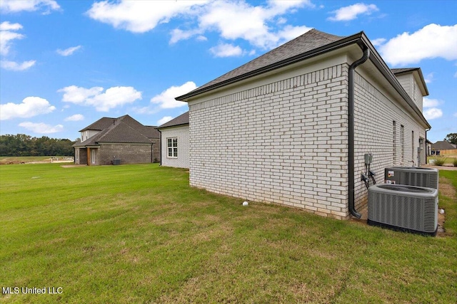 view of property exterior featuring central air condition unit and a yard