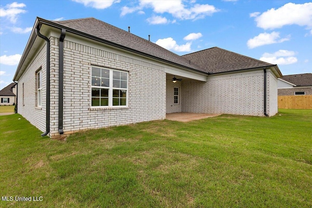 rear view of property with a yard and a patio