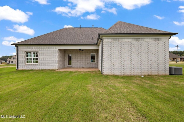 back of property with a patio area, central AC, and a lawn