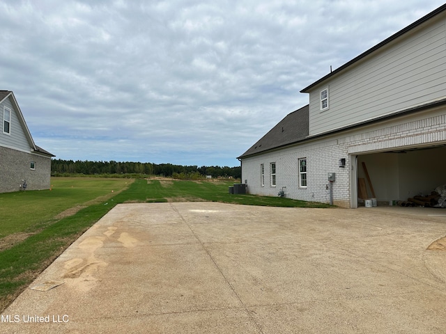 view of patio / terrace with central air condition unit and a garage