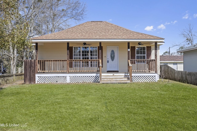 bungalow-style house with a shingled roof, a front lawn, ceiling fan, fence, and covered porch