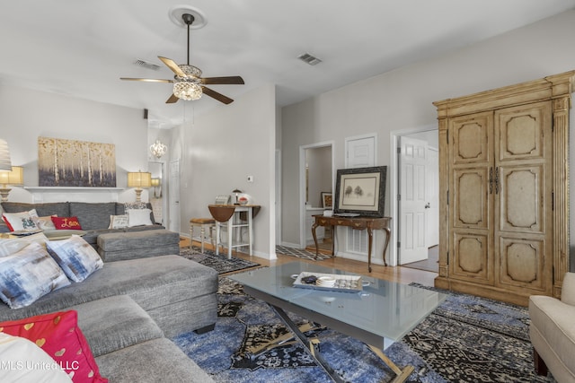 living area featuring visible vents, baseboards, wood finished floors, and a ceiling fan