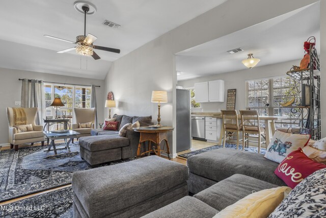 living area with vaulted ceiling, baseboards, visible vents, and ceiling fan