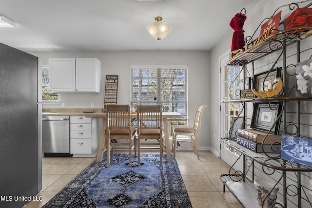 dining area with light tile patterned floors, baseboards, and plenty of natural light