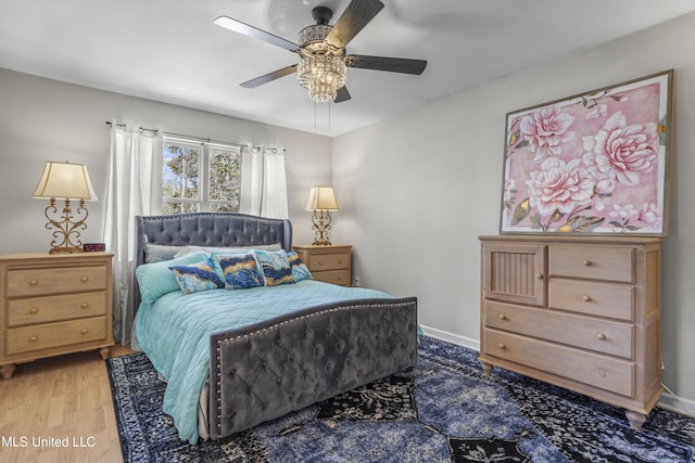 bedroom with ceiling fan, baseboards, and wood finished floors