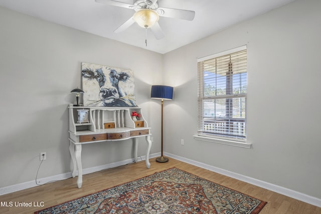 home office featuring a ceiling fan, wood finished floors, and baseboards