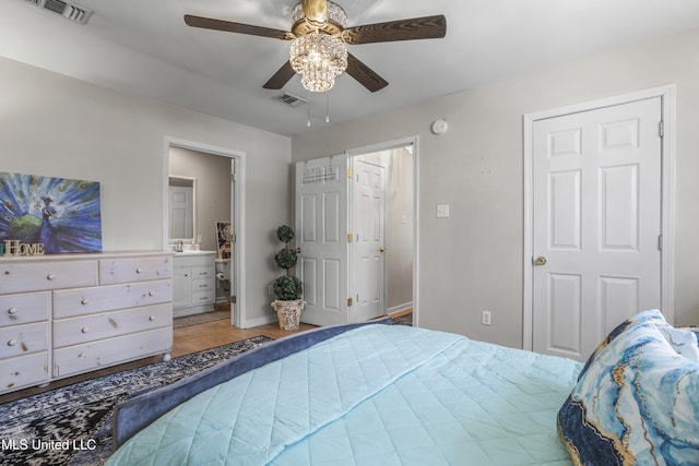 bedroom featuring visible vents, connected bathroom, ceiling fan, and wood finished floors